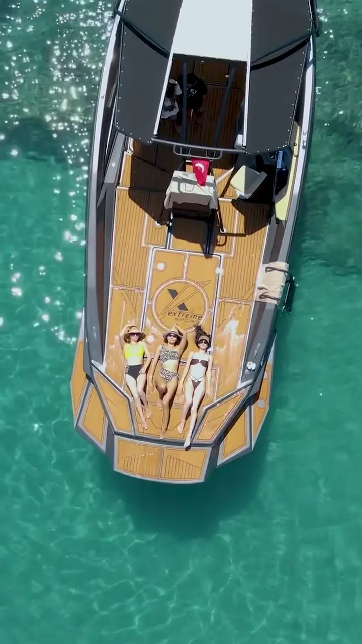 Aerial view of a longtail boat crossing clear turquoise water